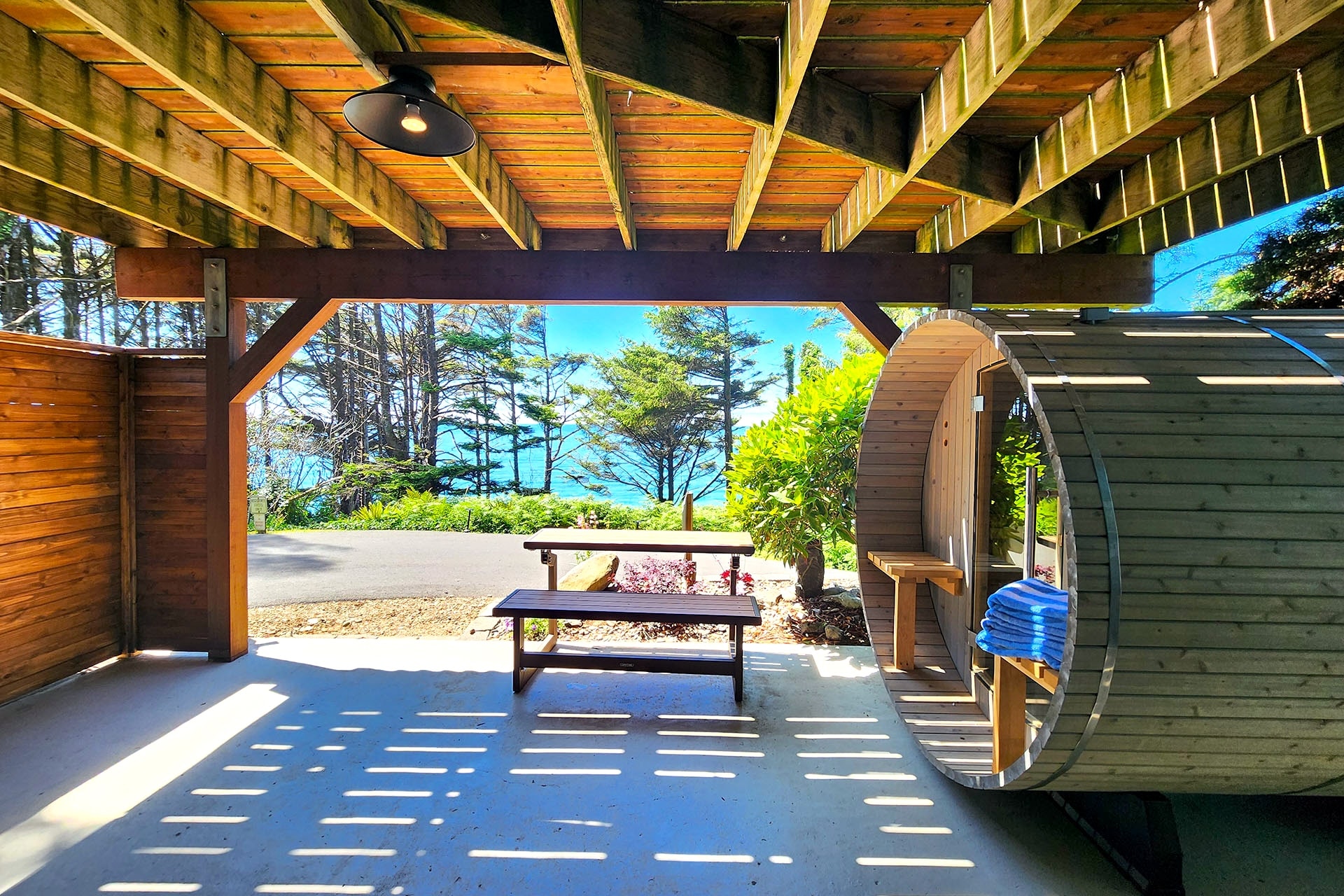The Mermaid's Den barrel sauna under covered pergola with ocean view
